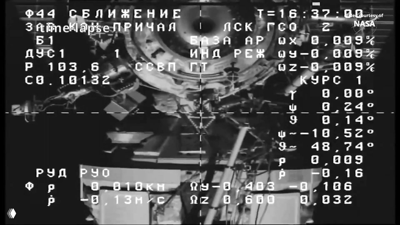 Чёрно-белый кадр видеотрансляции стыковки: стыковочный узел МКС с телеметрическими наложениями, цифровыми показателями и подписью «Courtesy of NASA».