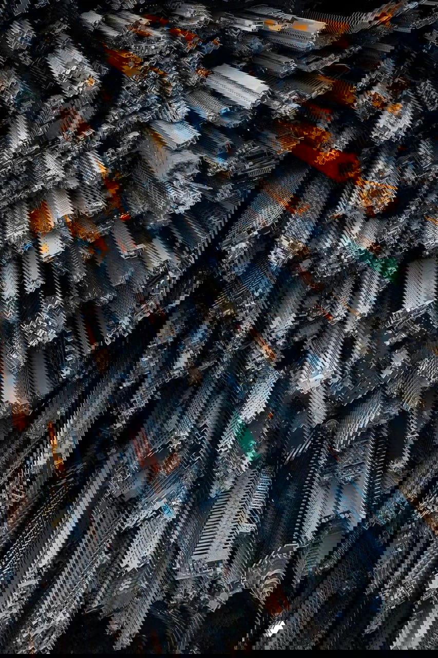 Вертикальная урбанистическая аэрофотография: плотная кладка небоскрёбов и архитектурная текстура города, съёмка сверху с дрона.