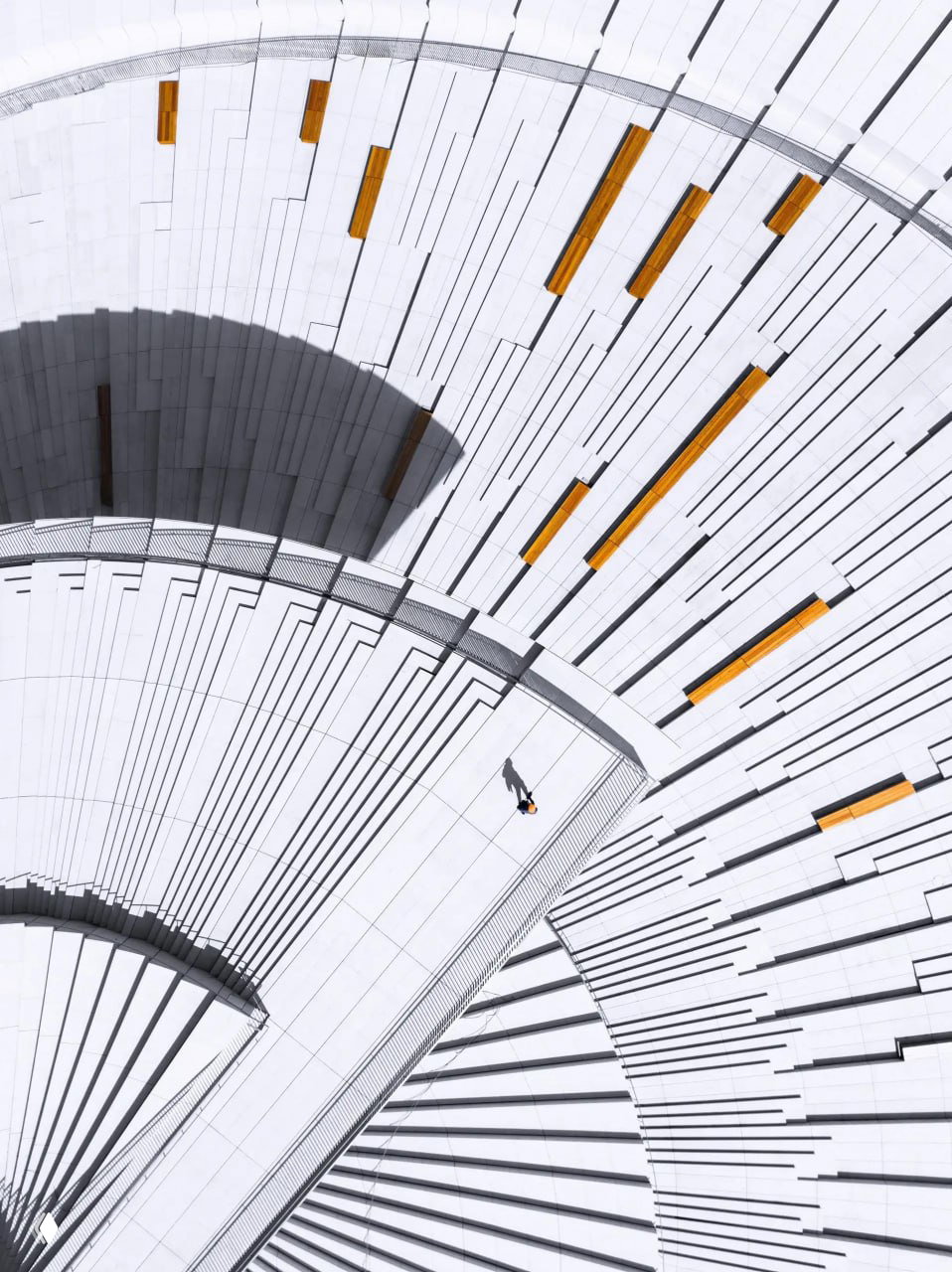 Геометрический кадр лестницы или амфитеатра сверху: белые ступени, ритм линий и одна крошечная фигура человека для масштаба.