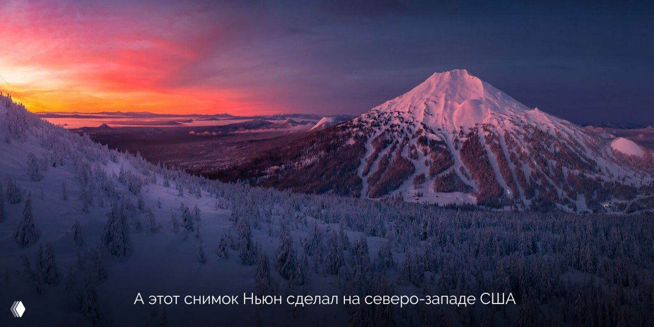 Панорамный зимний пейзаж северо-запада США с заснеженными склонами, холмами и подсвеченным розоватым небом на рассвете.
