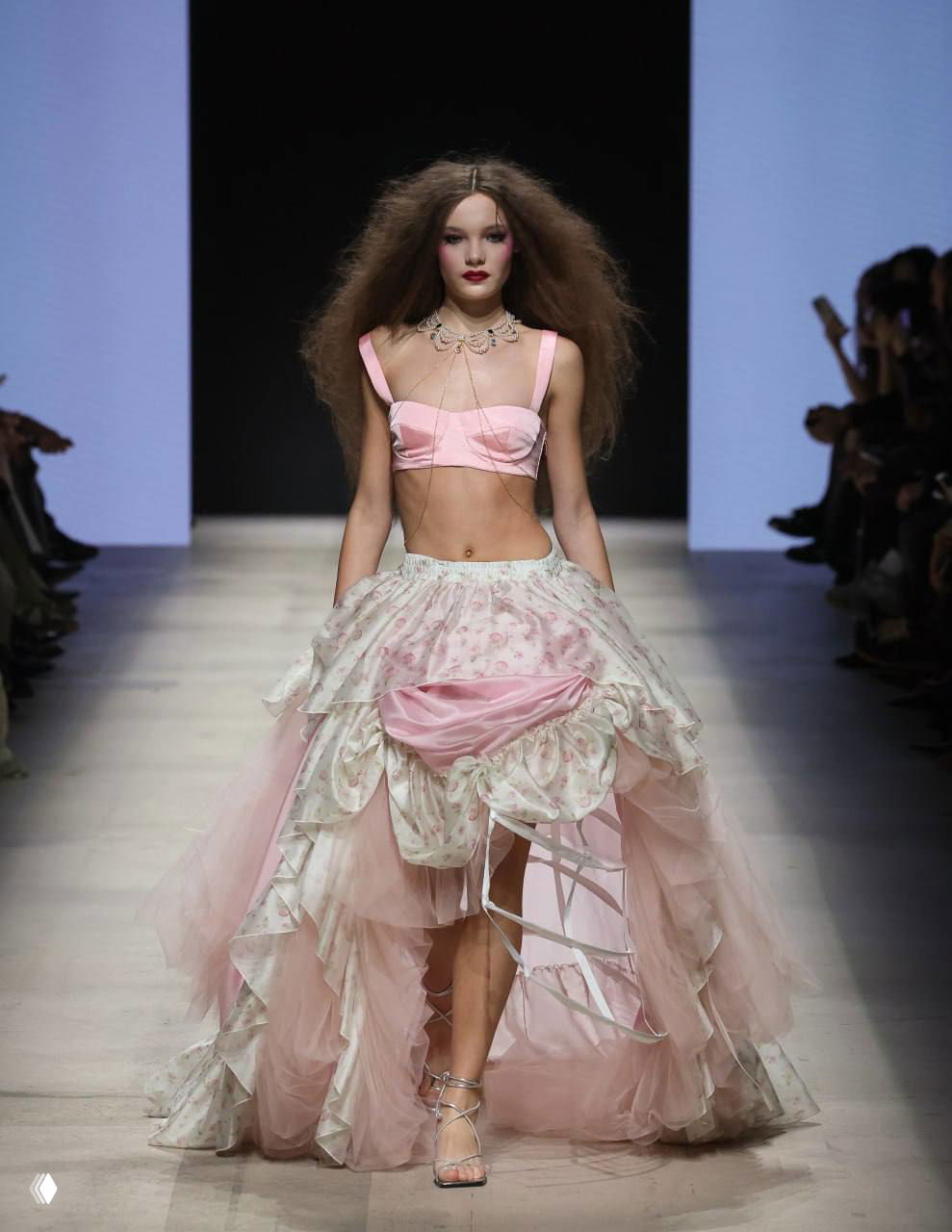 Модель в пышной розовой многослойной юбке и коротком топе, образ в духе Марии Антуанетты на показе коллекции «Roial Punk» в Манежe.