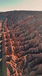 Аэрофотоснимок сухих оврагов и рифтов красно-коричневых пород в центральной части пустыни Атакама с выраженной эрозией почвы.