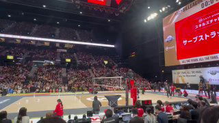 Панорамный вид на волейбольную площадку и трибуны во время матча в Японии — игроки, судьи и болельщики на арене.