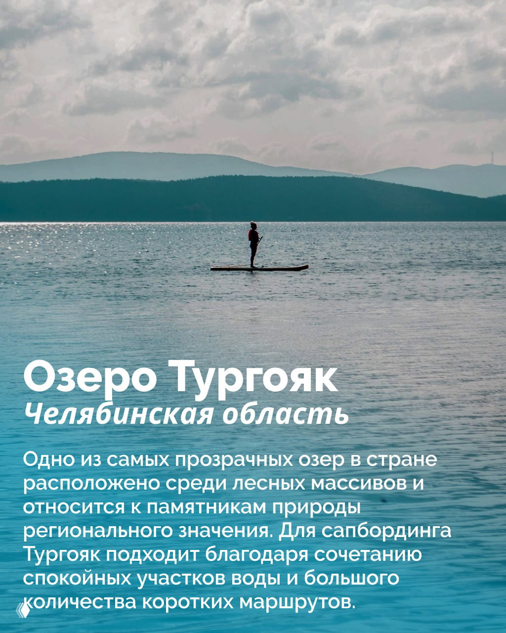 Силуэт человека стоящего на сапборде посреди спокойного озера, на заднем плане едва различимы горные хребты — кадр о тихих прогулках по Тургояку.