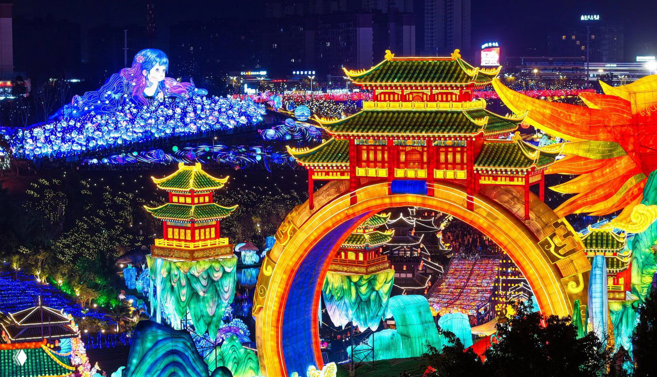 Арки и павильоны в восточном стиле, окружённые цветными световыми композициями и множеством посетителей — вид одной из зон 32-го фестиваля фонарей в Цзыгуне.