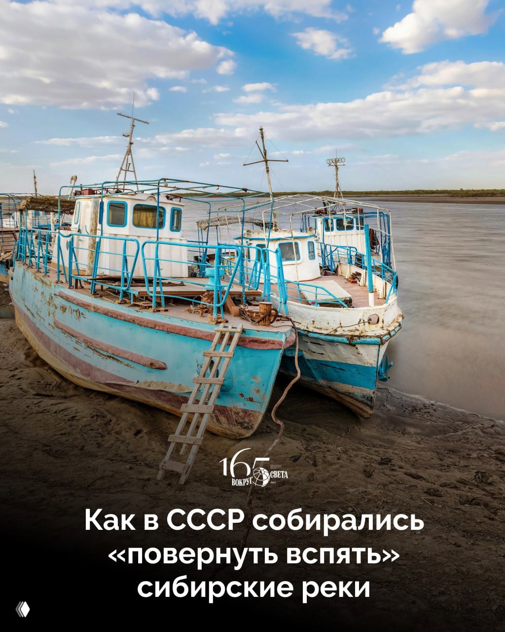 Две старые речные лодки на отмели широкой сибирской реки при низком уровне воды; вид береговой полосы и небо.