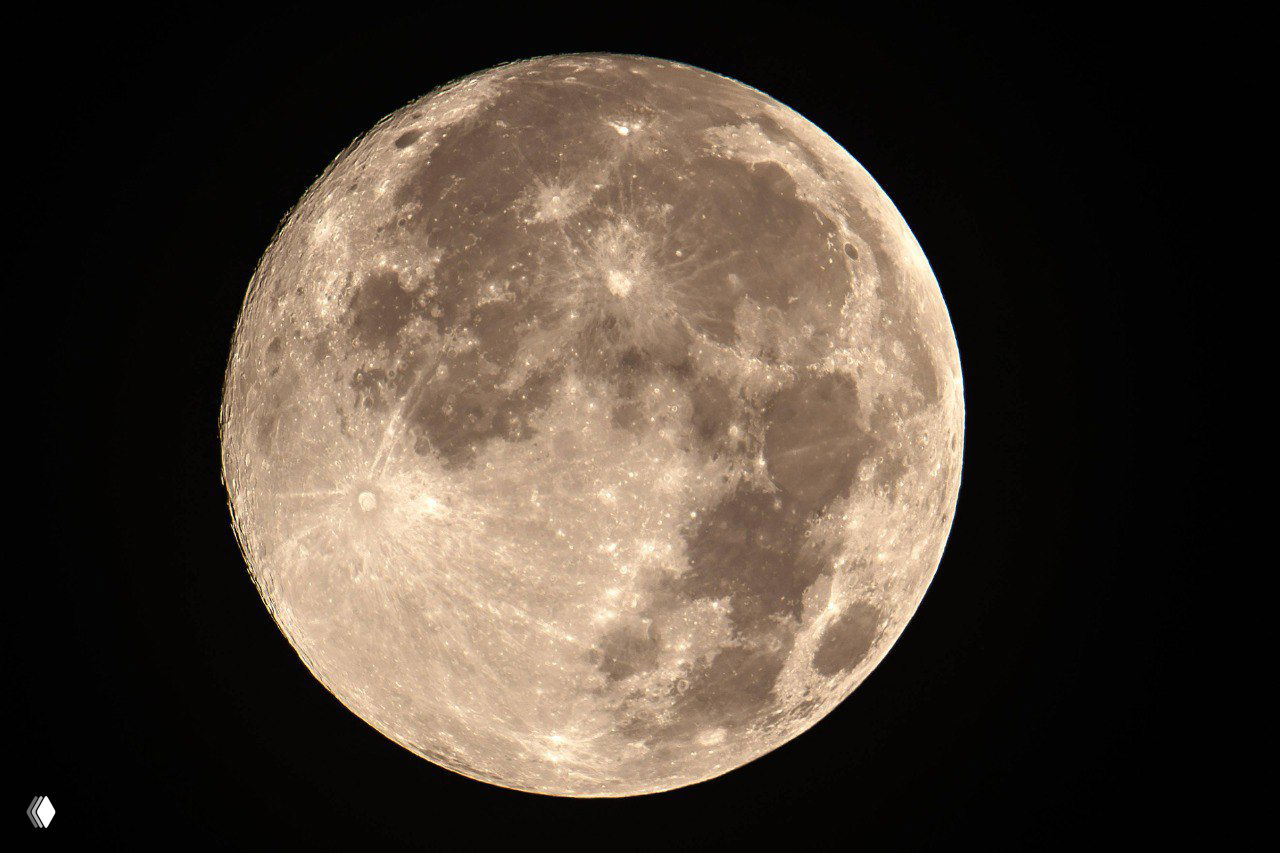 Крупный детализированный вид полной Луны с видимыми кратерами и светлыми лучами, нейтральный фон для наблюдения особенностей лунной поверхности