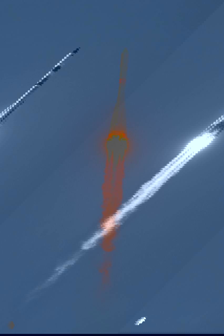 Ракета «Прогресс МС-33» в отрыве от стартовой площадки, вид в полёте на фоне голубого неба и шлейф продуктов сгорания моторов.