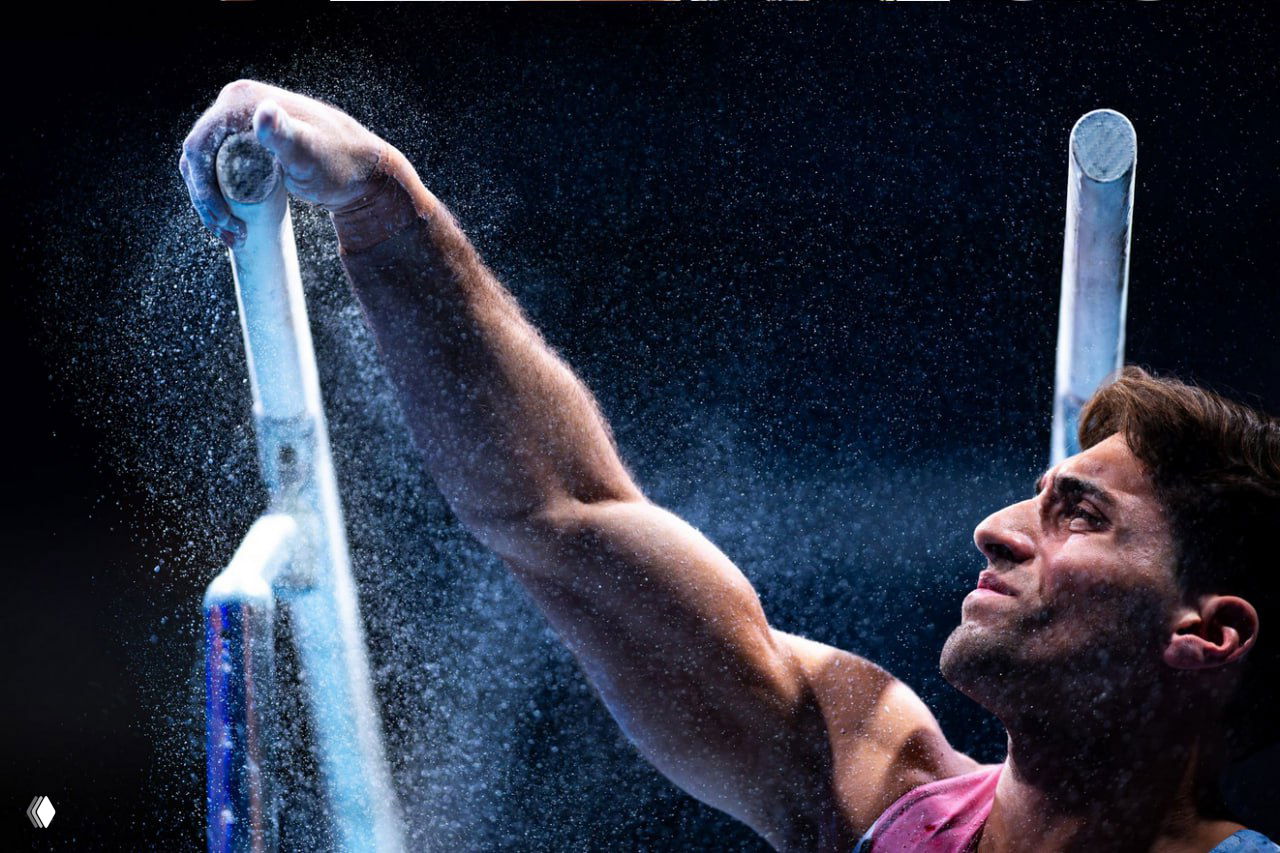 Гимнаст в момент подготовки к снаряду, порошок магнезии в воздухе — крупный эмоциональный портрет атлета из финалистов конкурса.