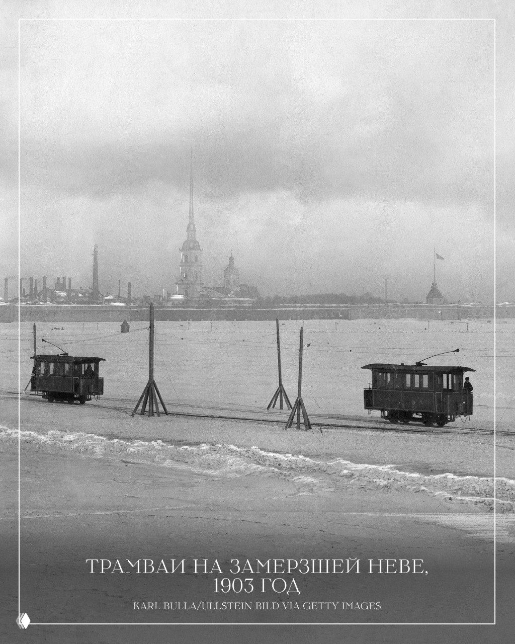 Чёрно‑белая фотография: трамваи едут по замёрзшей Неве на фоне силуэтов Петропавловской крепости и шпиля, зимний городской пейзаж 1903 года.