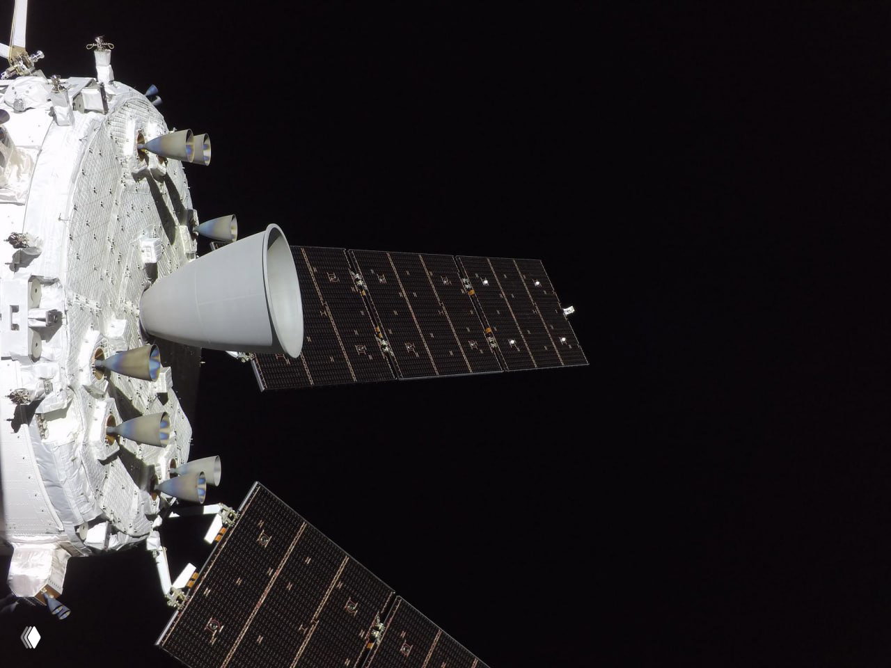 Развёрнутые солнечные панели и часть модуля «Орион» на фоне чёрного космоса; видны конструкции, крепления и элементы обшивки корабля.