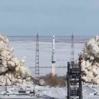 Момент старта «Протон‑М»: ракета отрывается от стола, вокруг поднимаются облака дыма и пламени, видна траектория подъёма.