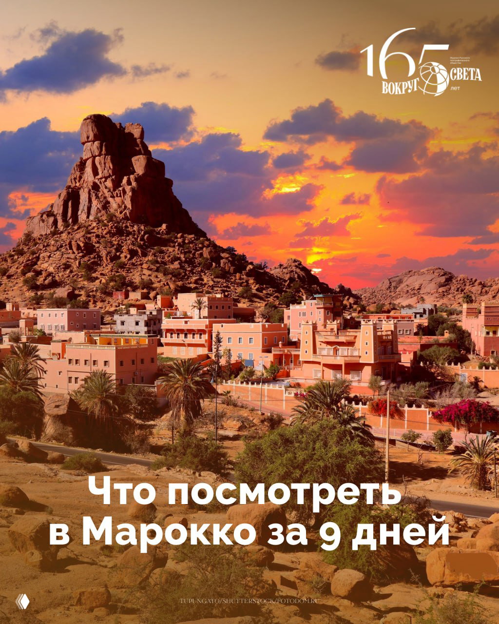 Панорамный вид марокканского городка у скалистой возвышенности вечером: тёплые дома, пальмы и пустынный пейзаж на фоне яркого заката.