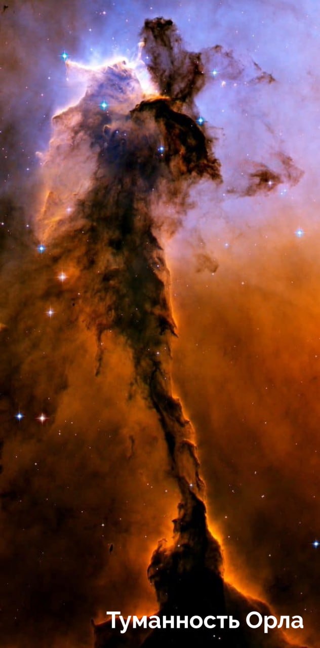 Вертикальное изображение тёмной колонны газа и пыли — «Туманность Орла», с подсвеченными краями и яркими фонарными точками звёзд на фоне.