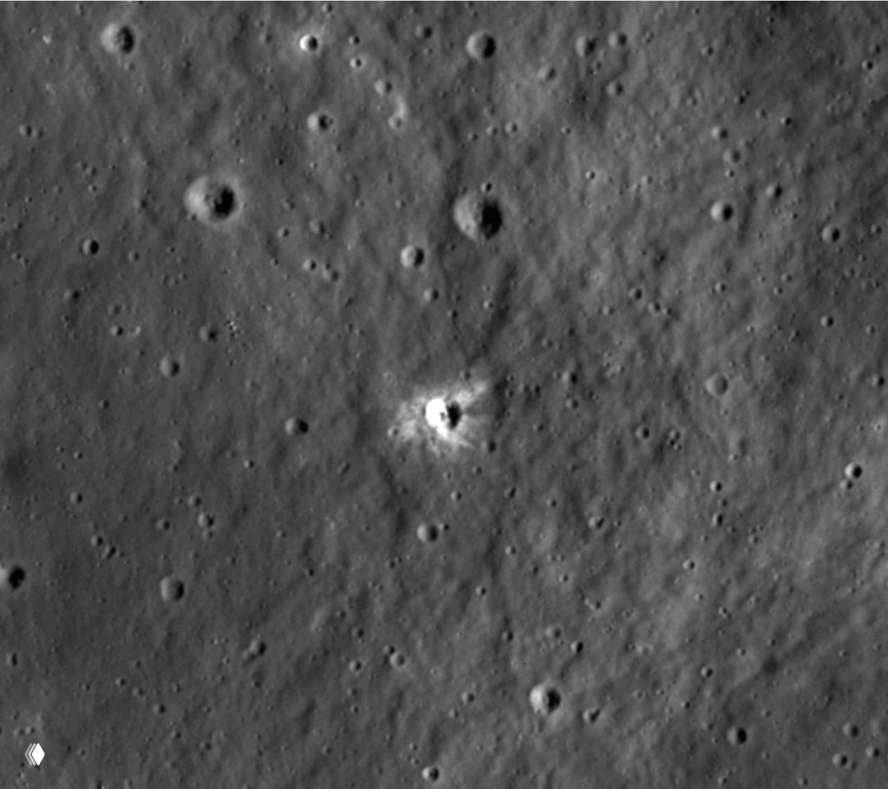 Детальный снимок образовавшегося кратера диаметром 225 м с яркими лучами выброшенного материала и темным центральным углублением.