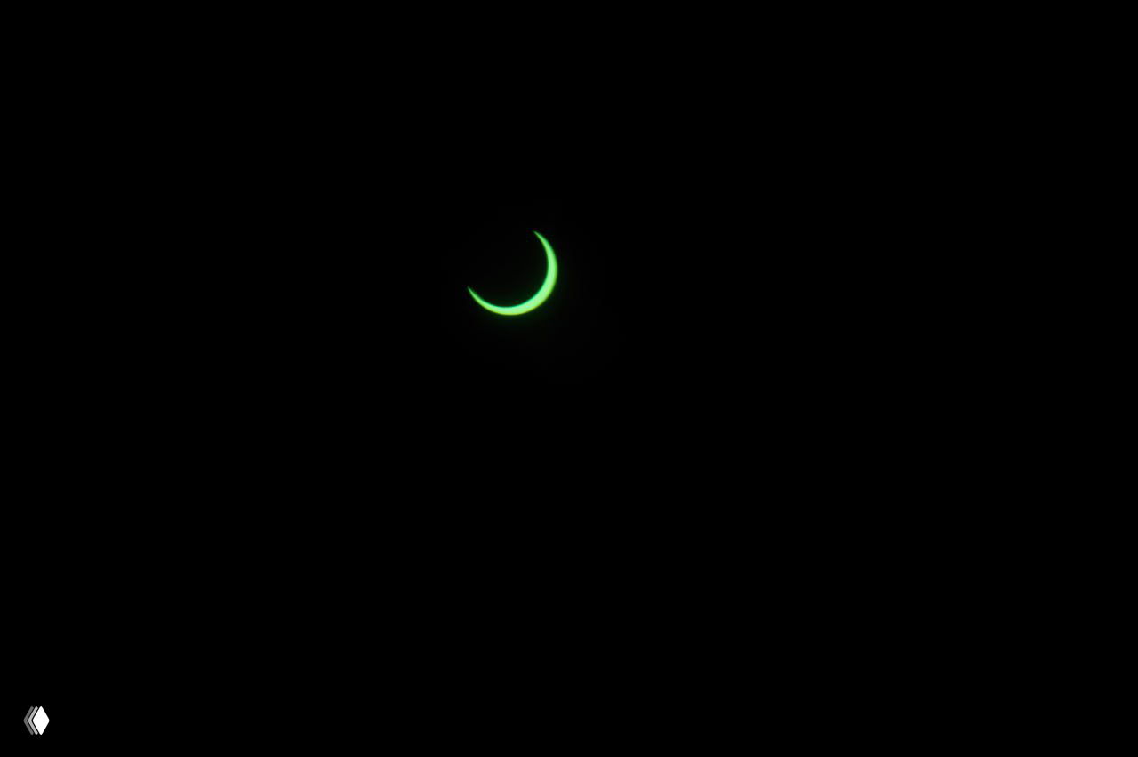 Тонкая изогнутая видимая часть Солнца на чёрном фоне — фотография «кольца» Солнца во время антарктического затмения.