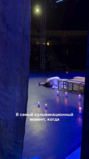 Кадр со сцены в Измире: актёр в образе Ромео лежит в склепе, видна часть сцены и затемнённые ряды зрителей.