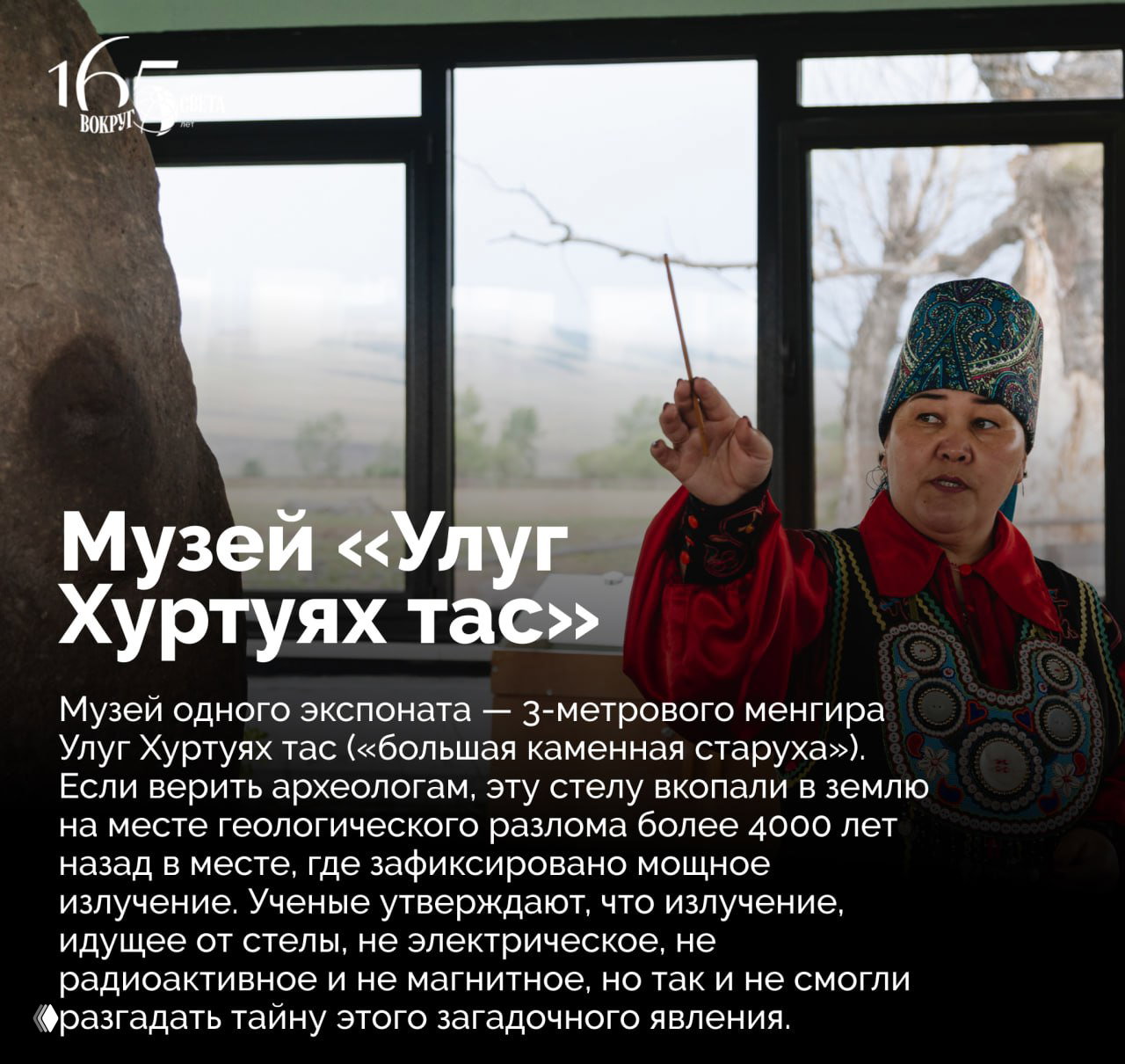 Интерьер музея с экскурсоводом в национальной одежде и крупным каменным менгиром — экспонат «Улуг Хуртуях тас», рассказ о древней стеле.