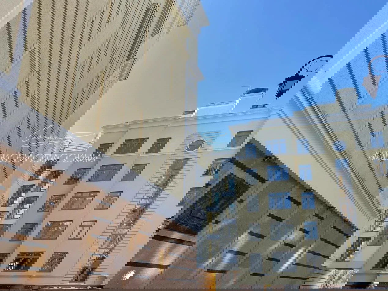 Фрагменты архитектурного оформления фасада жилого комплекса: декоративные элементы, лоджии и светлая штукатурка в классическом стиле.