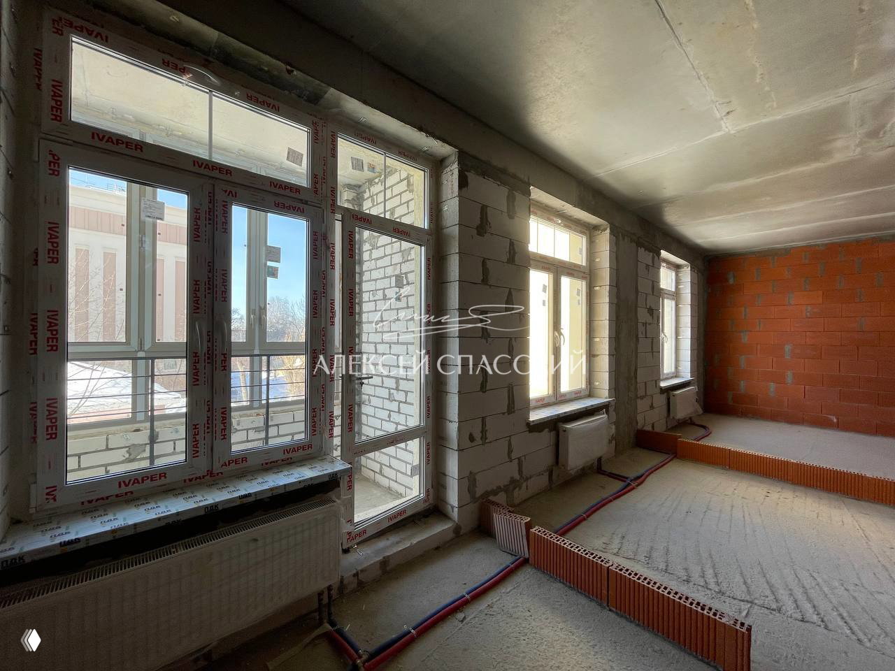 Окна и балкон квартиры в ЖК «Дворянский»: крупные пластиковые окна и выход на лоджию, вид на улицу Гоголя и освещённое помещение.