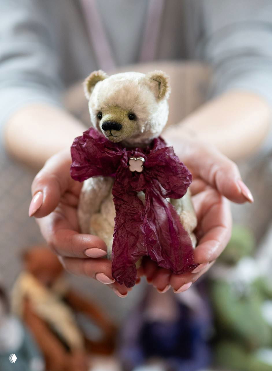 Ручная кукла — маленький плюшевый мишка в руках мастера, акцент на текстуре и декоративной ленте, фото для анонса участников маркета.
