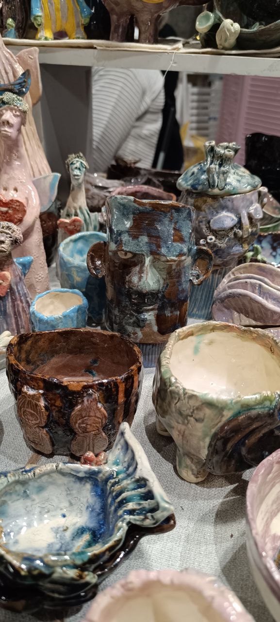 Ряд пластиковых и керамических кашпо рифлёной и гладкой фактуры разных цветов и размеров, выставленных в ряд на столе на мероприятии Green Market в Казани.