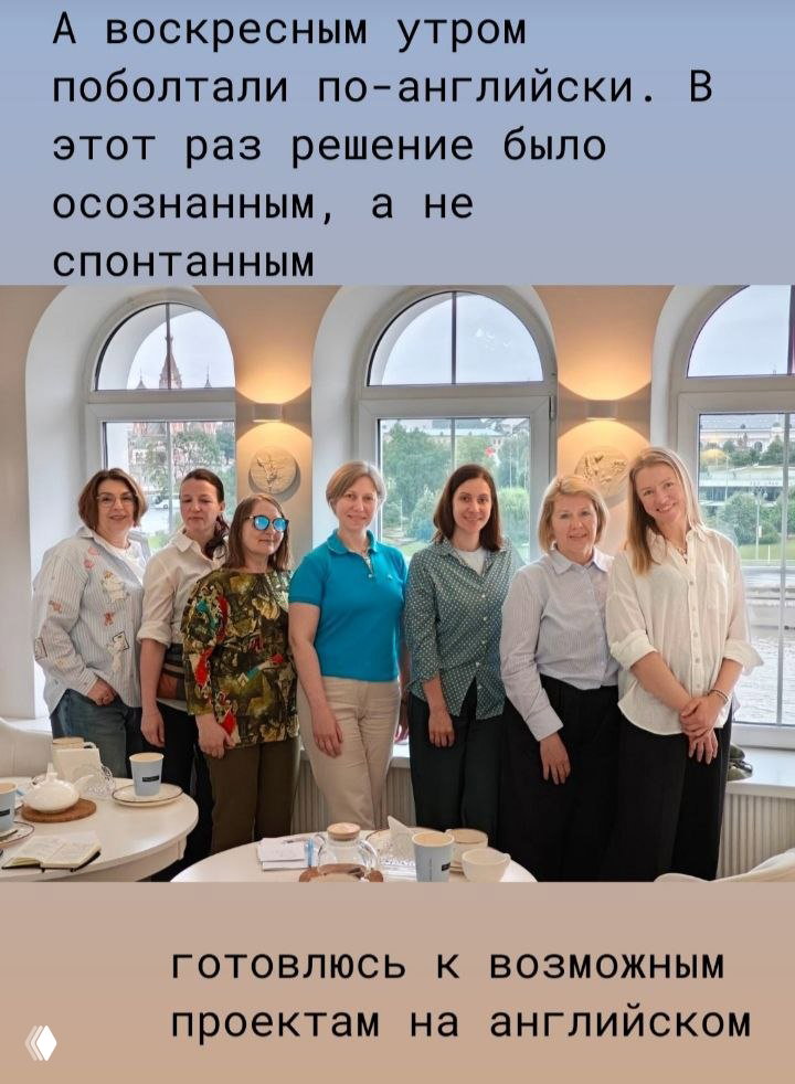 Групповое фото участников встречи: семь женщин в светлой комнате у больших арочных окон, виднеется зеленый берег и Храм Василия Блаженного.