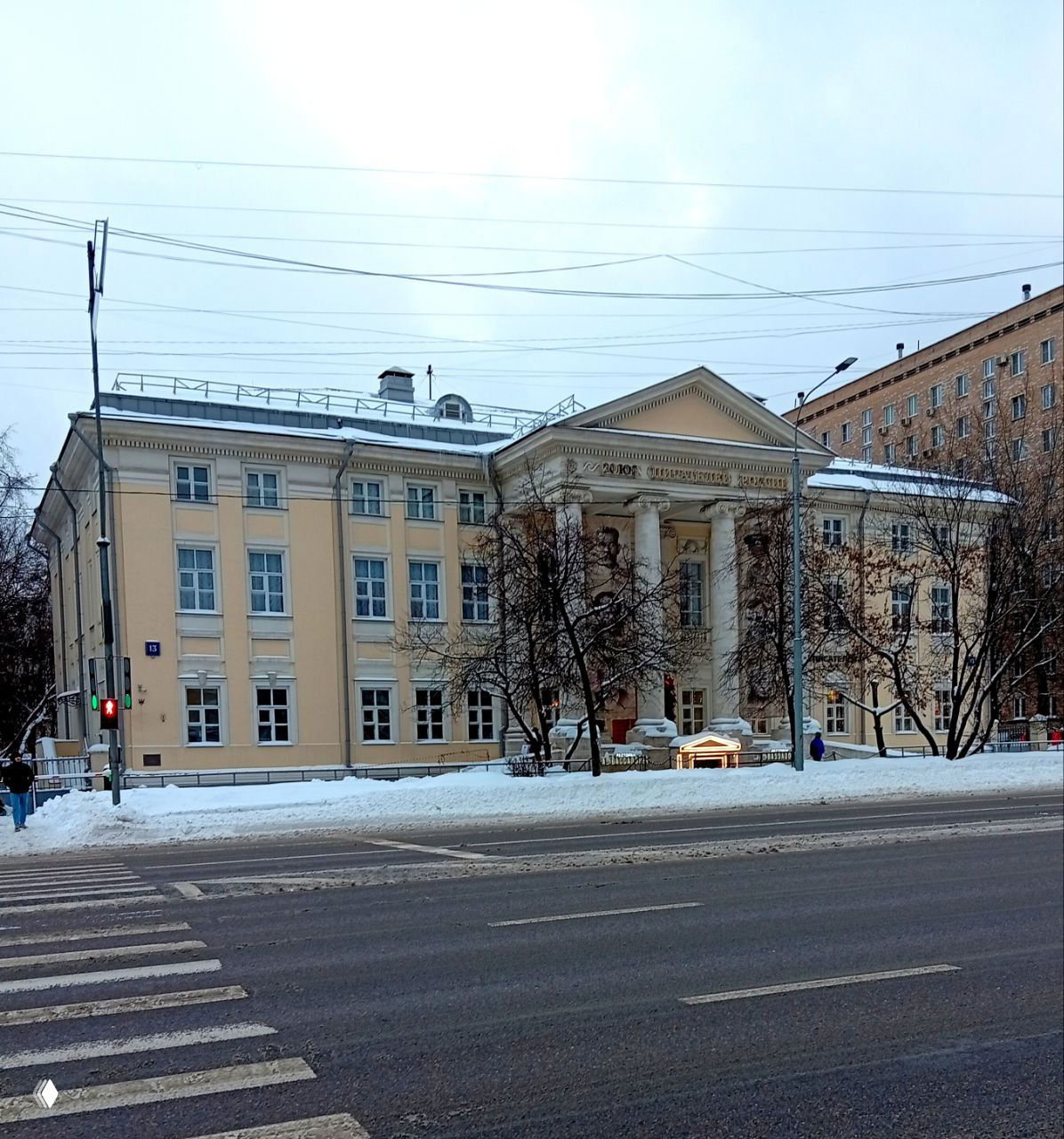 Фасад здания с колоннами и фронтоном — Дом Союза писателей России зимой, заснеженная улица перед входом, место проведения мероприятия.