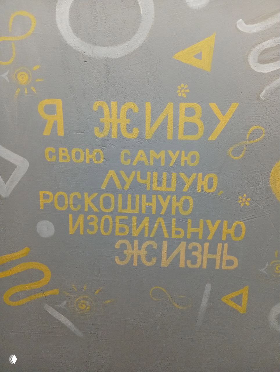 Мотивирующая фраза на стене заведения золотыми буквами: позитивная надпись в интерьере, дополняющая тёплую атмосферу книжной встречи.