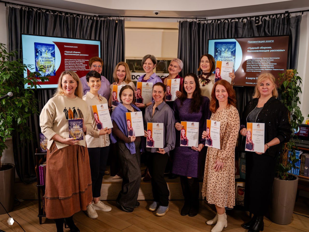 Групповая фотография пятнадцати женщин с сертификатами и книгами на презентации сборника в книжном магазине — авторы и участницы события.