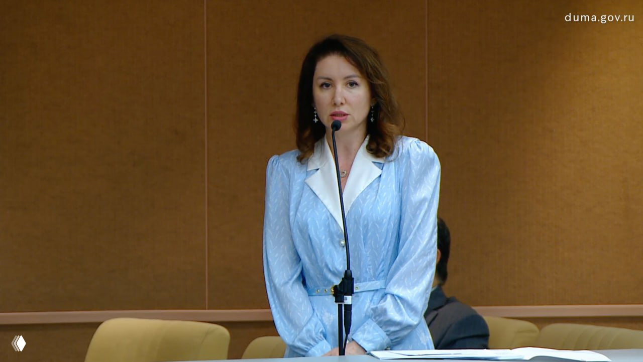 Женщина у микрофона в зале Госдумы во время доклада о бюджетной ситуации; кадр с официальной видеотрансляции.