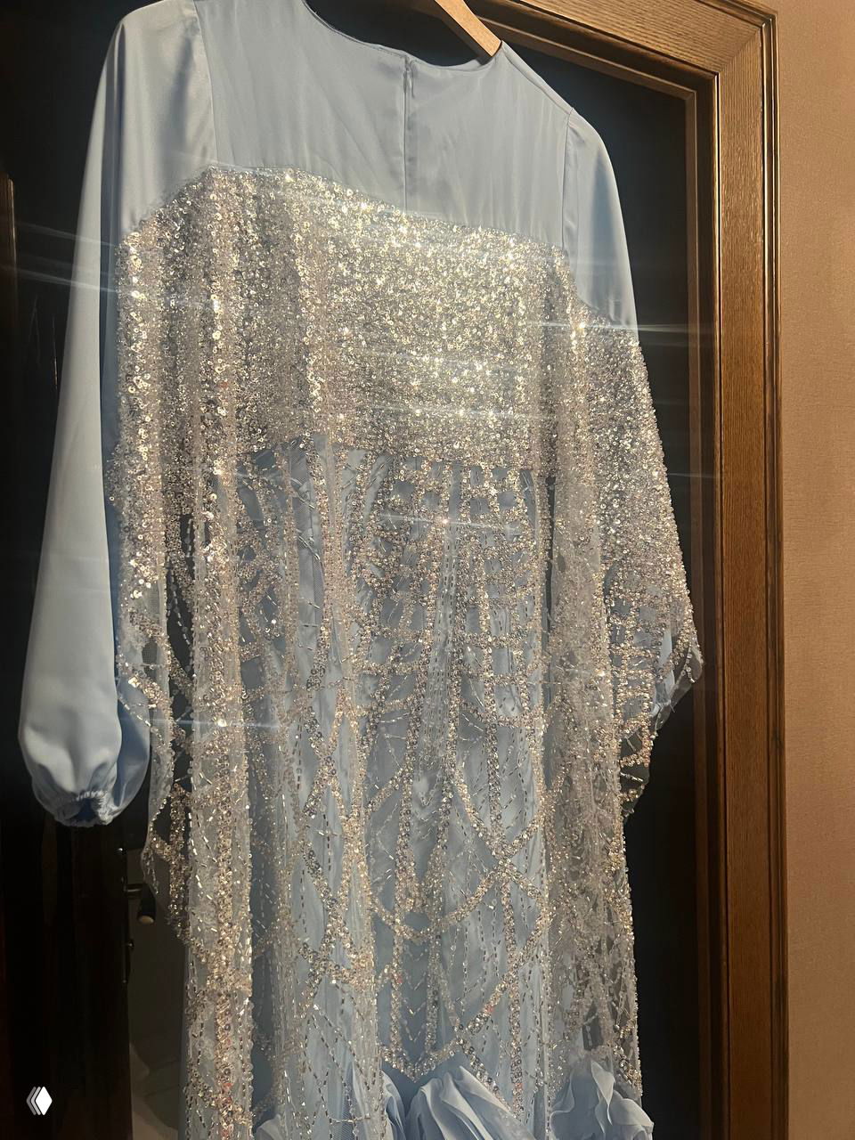 Голубое платье с пришитой сверху прозрачной сверкающей накидкой — узор из бисера и пайеток образует мерцающий фасад костюма.