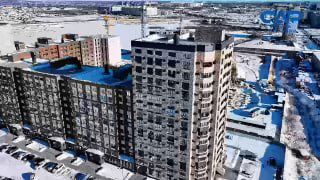 Панорамный вид жилого комплекса «Современник» зимой: многоквартирные дома, заснеженная придомовая территория и элементы стройки на заднем плане.