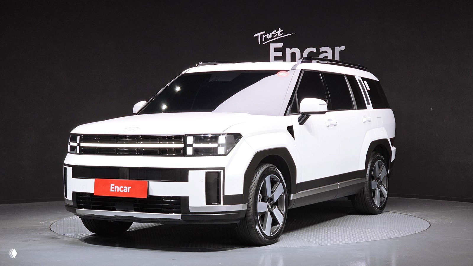 Фронтально‑угловой вид белого Hyundai Santa Fe MX5 на подиуме; хорошо видна решётка радиатора, фары и общий дизайн кузова.