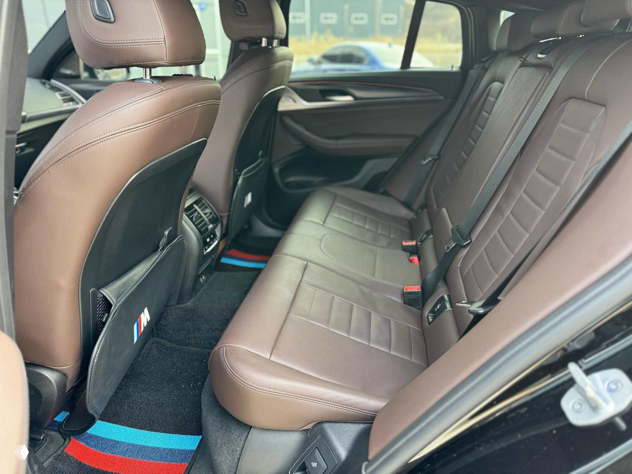 Задний ряд сидений BMW X4 с коричневой кожей, запас места и вид на заднюю часть салона — чисто и без видимых повреждений.