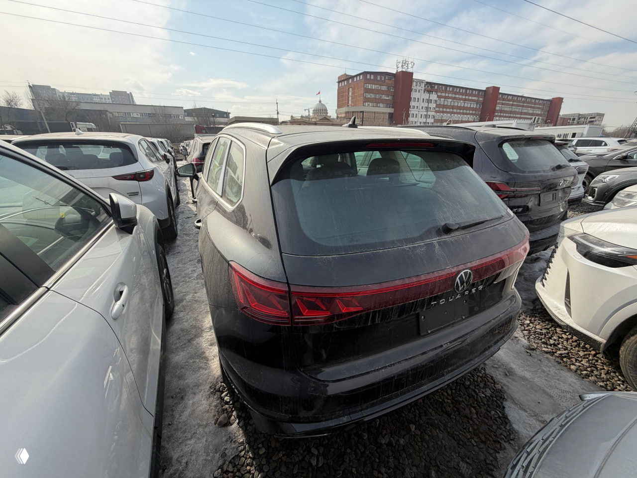 Сзади-сбоку вид на чёрный Volkswagen Touareg — видна светодиодная задняя оптика и общая компоновка багажной части автомобиля.