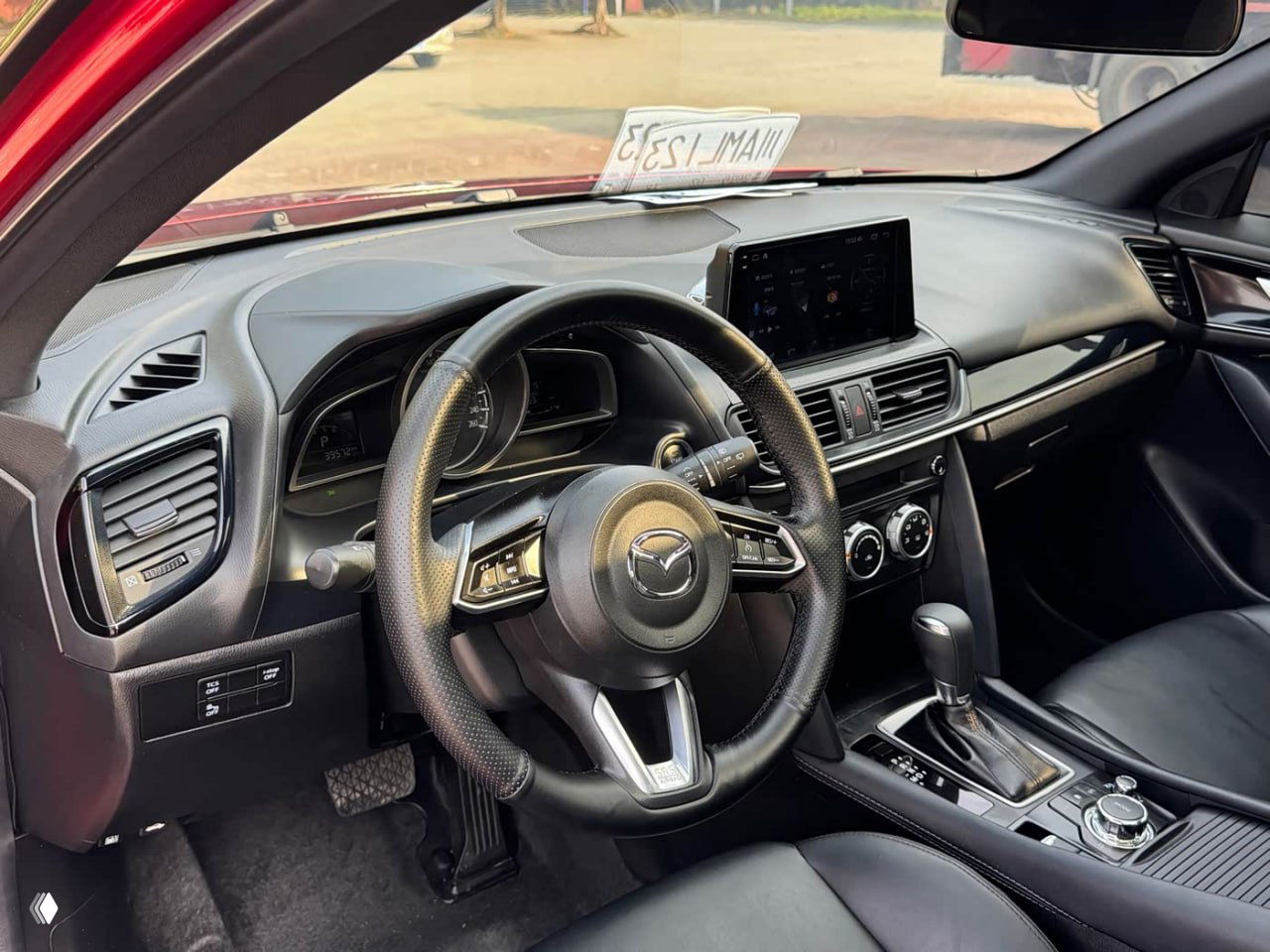 Салон Mazda CX-4: вид на рулевую колонку, мультимедиа экран и центральную консоль с селектором автоматической коробки передач.