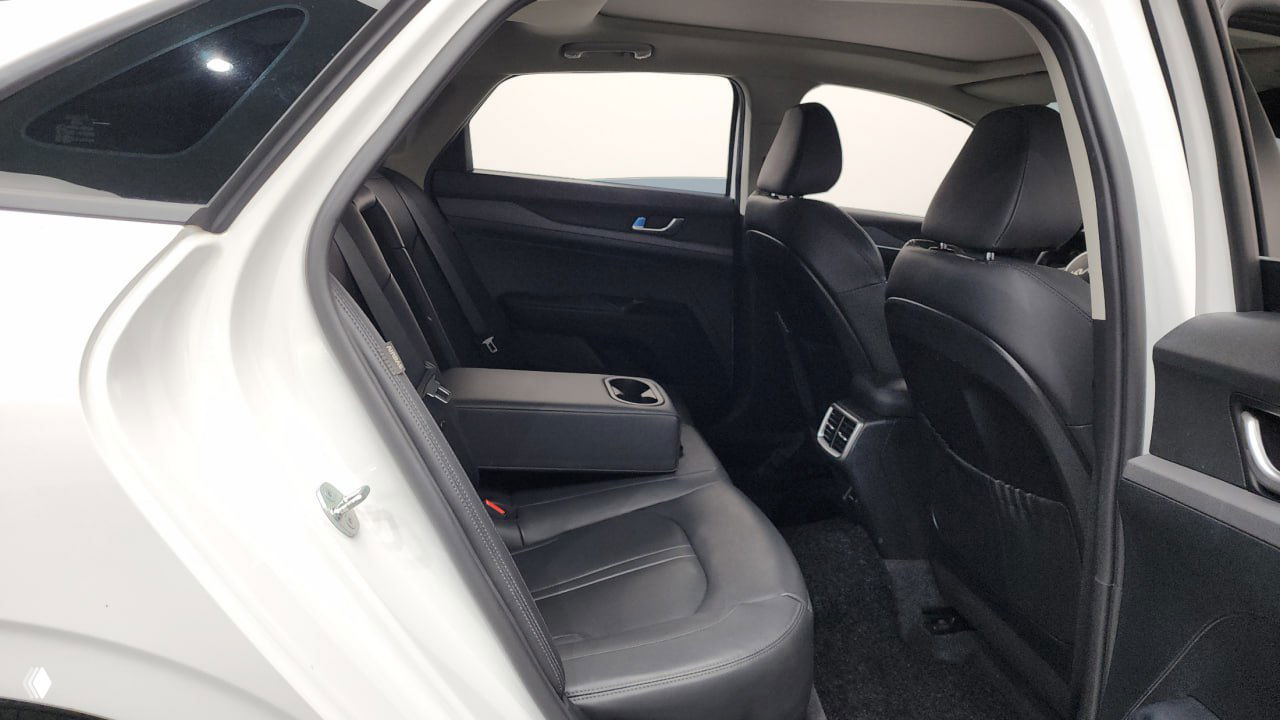 Задние сиденья Kia K5: раскладной подлокотник с подстаканниками, чистая чёрная обивка и дефлекторы для задних пассажиров, общий вид салона