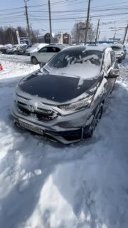 Передний вид Honda CR‑V 2021 в снегу на стоянке, автомобиль спереди‑слева; на кадре видна лицевая часть машины и частично регистрационный номер