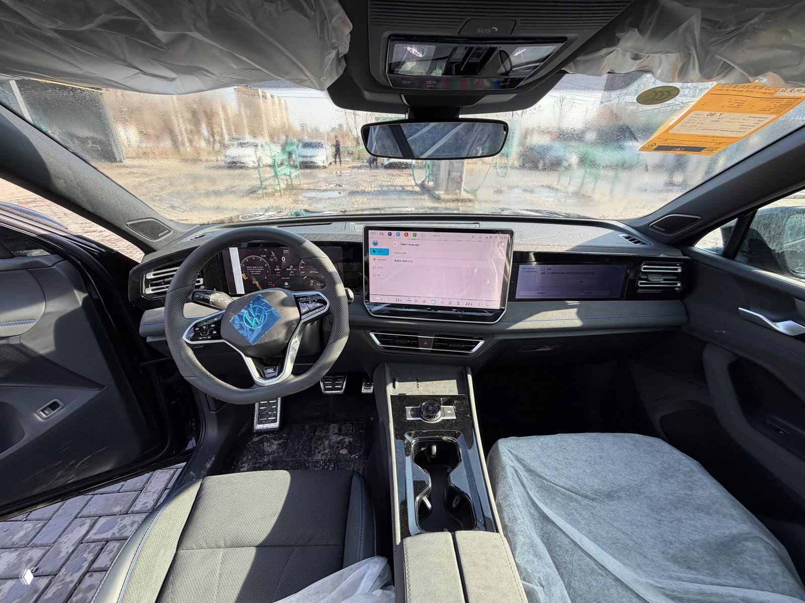 Широкий снимок передней панели и салона Volkswagen Tiguan L Pro: мультимедийный экран, руль и центральная консоль видно с места водителя.