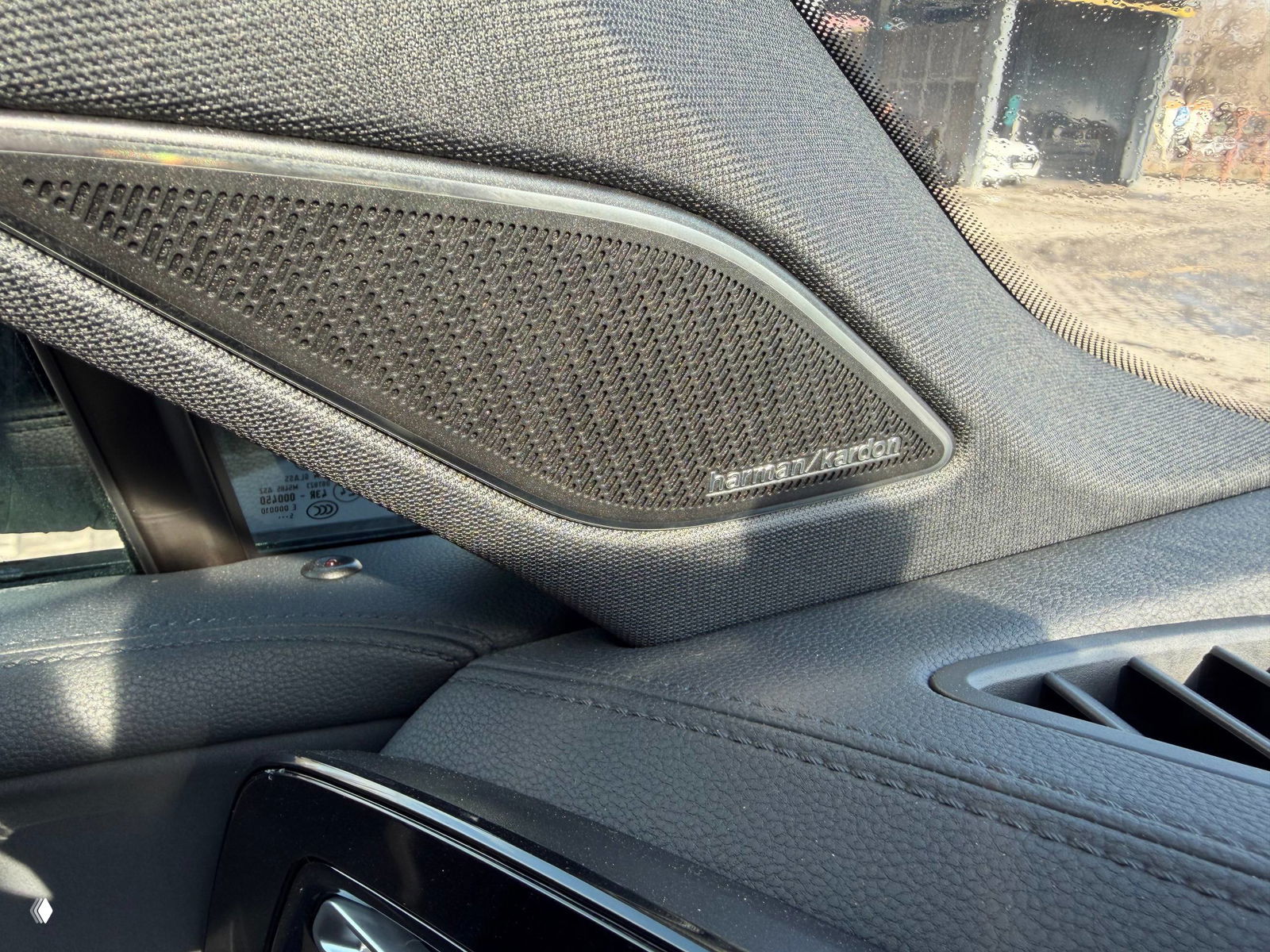 Крупный план динамика Harman/Kardon в интерьере Tiguan L Pro: решётка динамика и отделка дверного проёма, подчёркивающие аудиосистему.