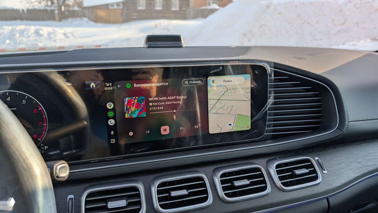 Центральный сенсорный дисплей и мультимедийный блок Mercedes‑GLE с отображением музыки и картографией, крупный план торпедо и воздуховодов.