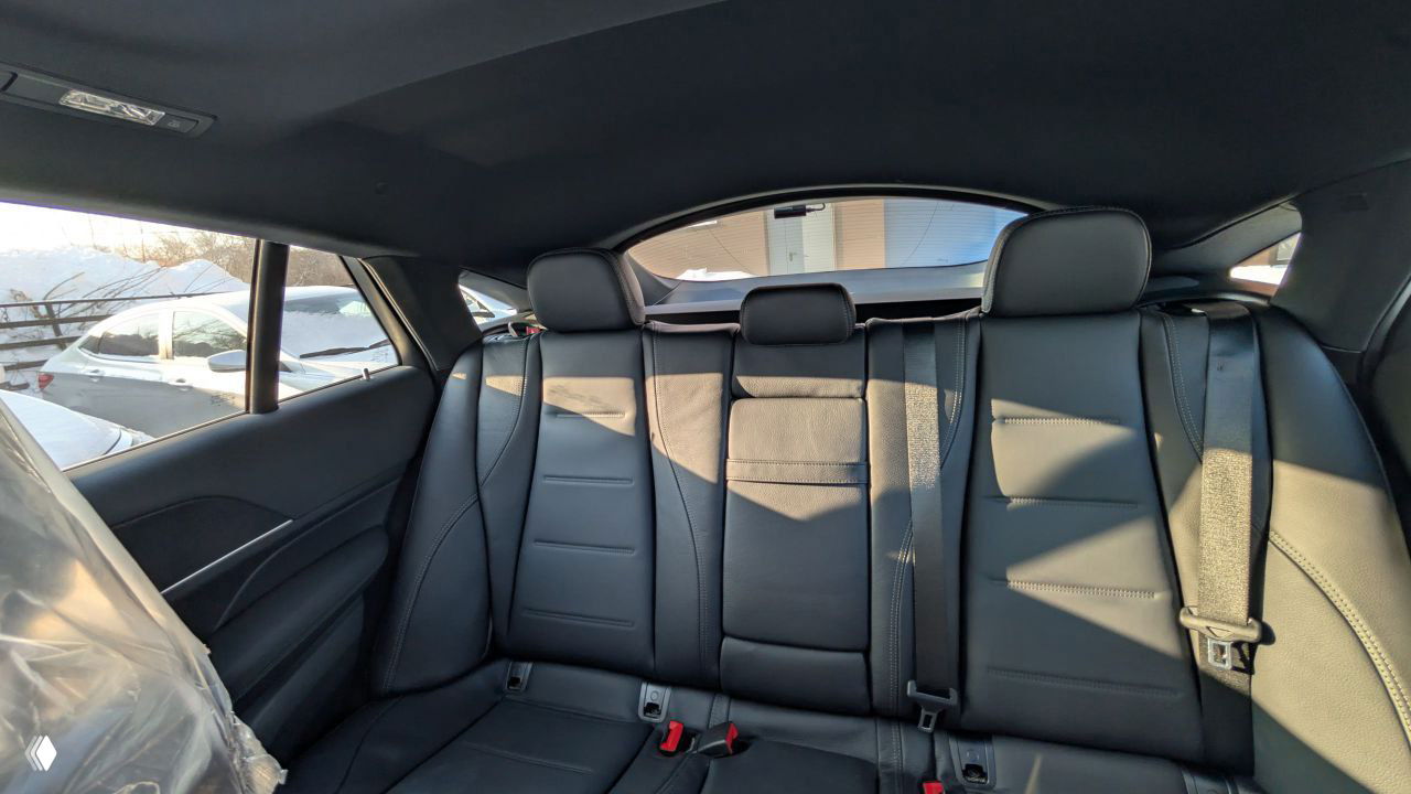 Задний ряд сидений Mercedes‑GLE: черная кожа, три подголовника и ремни безопасности, общий вид салона и боковых окон с зимним фоном.