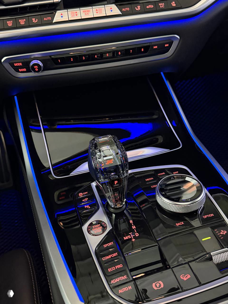 Блок управления коробкой передач и набор кнопок режимов (Sport, Comfort, Eco Pro) в BMW X7 с кристаллическим селектором и подсветкой вокруг.