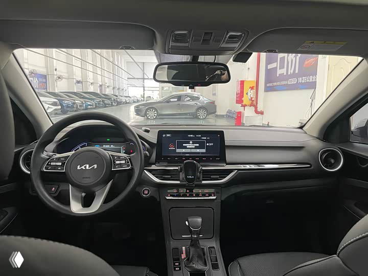 Салон Kia K3 — общий вид приборной панели, мультимедиа экран и рулевая колонка; демонстрируется состояние центральной части салона.