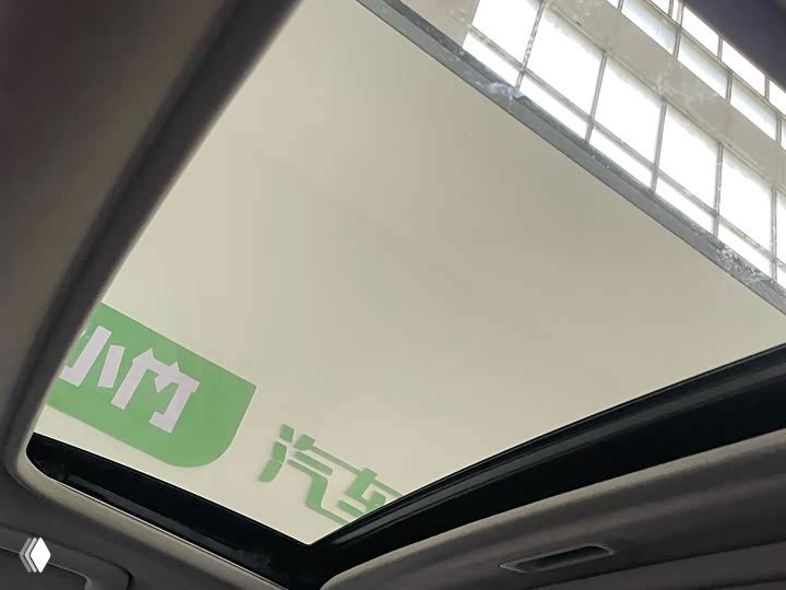 Стеклянный люк в крыше Kia K3, вид из салона вверх: показан контур люка, солнцезащитный экран и часть потолочной обивки автомобиля.