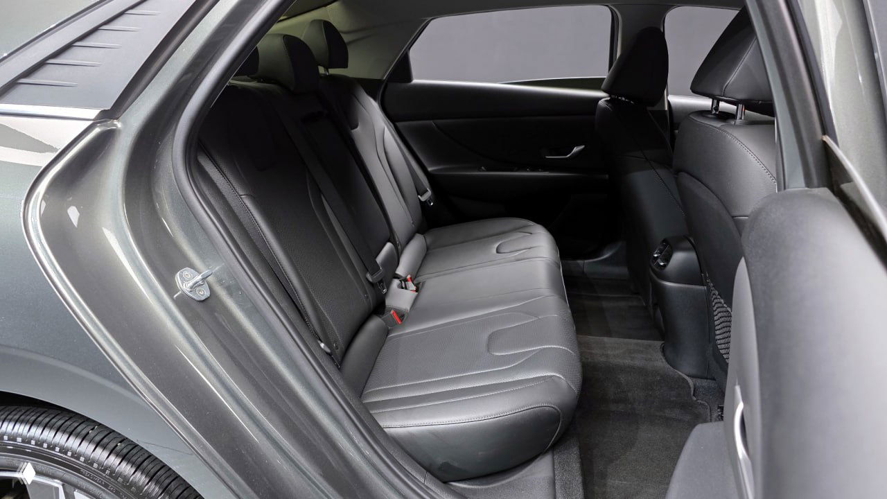 Фотография задних сидений Hyundai AVANTE: просторный салон и целая задняя лавка с трехточечными ремнями безопасности и тканевой/кожаной отделкой.