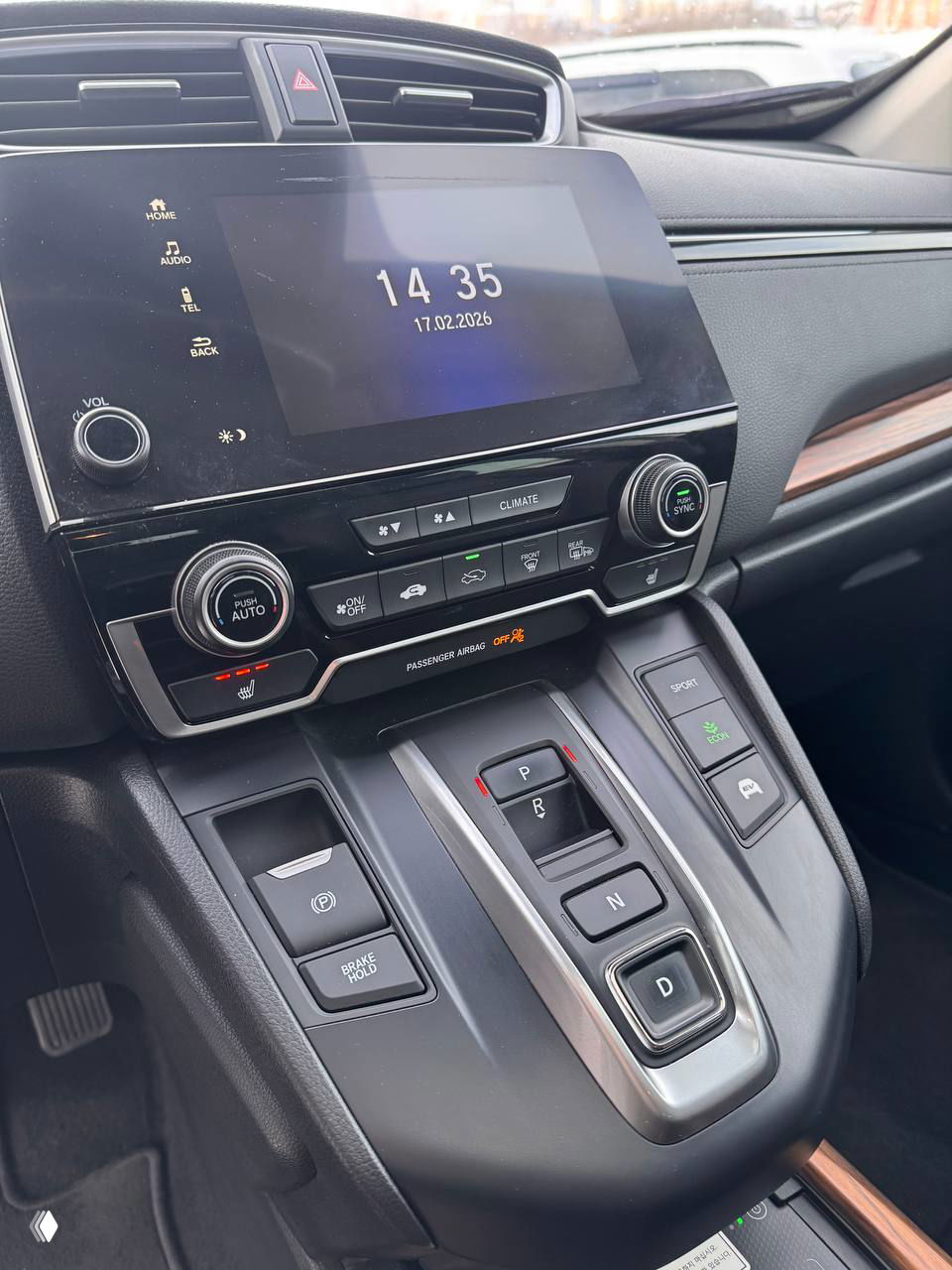 Крупный план центральной консоли Honda CR‑V 2021: сенсорный экран, органы управления климатом и селектор режимов движения на фоне чистого интерьера.