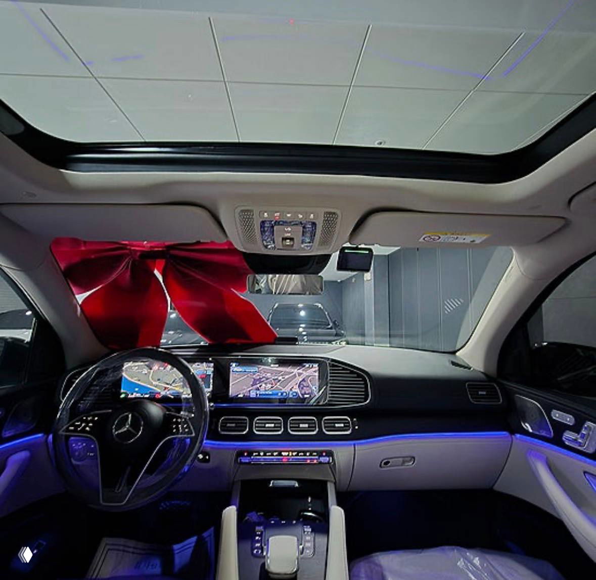 Панорамный вид на приборную панель и центральную консоль Mercedes‑Benz GLE‑Class с включённой атмосферной подсветкой и мультимедиа‑экранами.