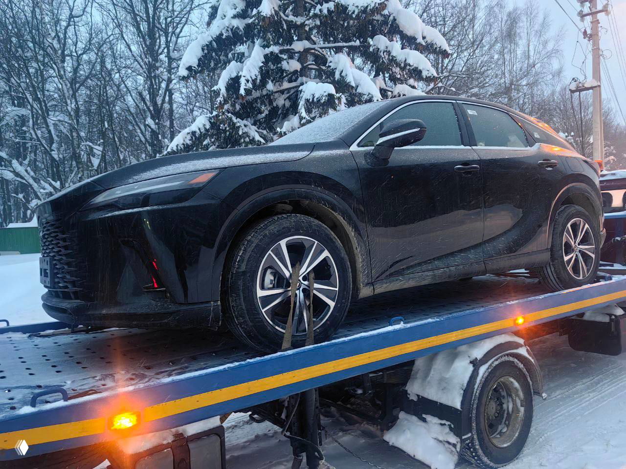 Чёрный Lexus RX 300 на платформе, боковой профиль автомобиля виден целиком, колёса фиксированы стропами, ночная зимняя дорога и хвойные деревья.
